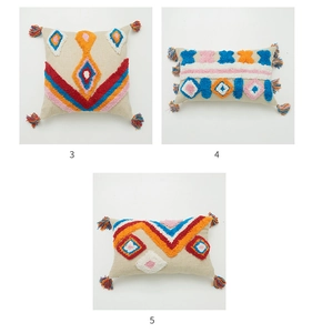 Close-up of geometric tufted patterns and colorful tassels on bohemian pillow covers