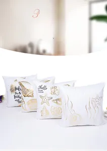 Detail of four gold foil ocean cushion covers featuring shell and starfish patterns