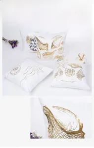 Detail of gold foil marine patterns like shells and starfish on soft white cushion covers