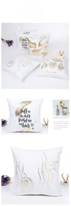 Detail of nautical pillow covers with gold foil starfish and shell patterns on white linen