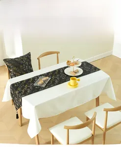 Detail of black table runner with gold geometric patterns and decorative tassels
