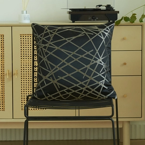 Modern black square pillow cover with silver geometric stripes on a stylish metal chair