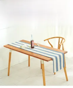 Detailed texture of blue and white striped cotton linen table runner on dark wood table