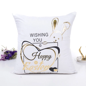 Easter throw pillow case with golden bunny ears and Happy Easter message on white fabric