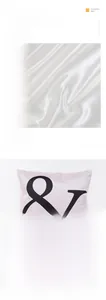 Close-up of pink imitation silk pillowcase with black ampersand print texture
