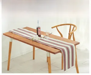 Detailed knit texture of linen striped table runner on light wood dining table surface