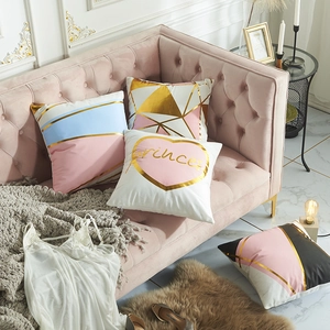 Pink and gold geometric throw pillow covers with Princess print on a velvet sofa
