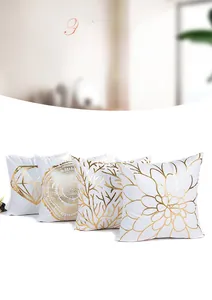 Detail of four square pillow covers with gold foil geometric and floral patterns