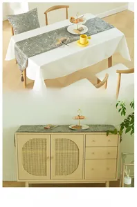 Detailed view of gray geometric mosaic table runner with decorative tassels and texture