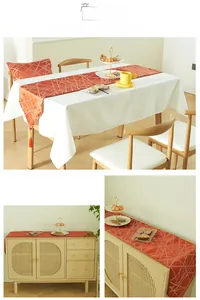 Detail of modern orange geometric table runner with tassels and matching pillow cases