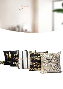 Detail of five gold foil cushion covers featuring black white geometric feather patterns