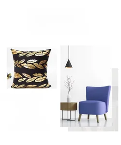 Detail of black throw pillow case with metallic gold feather print on a modern chair