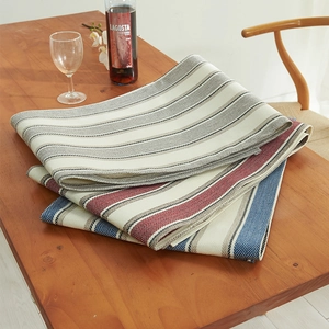 Linen cotton table runner with wide stripes and herringbone weave on dark wood table