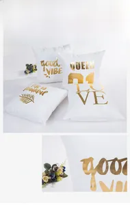 Close-up of golden foil lettering and soft fabric texture on modern white pillowcases