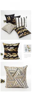 Detailed view of black and gold pillow covers with feathers and geometric patterns