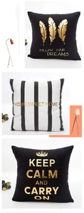 Detail of gold foil pillow covers with feather and geometric patterns on white background