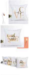 Detail of white plush pillowcase with gold stamped LOVE and LIFE text in a cozy setting