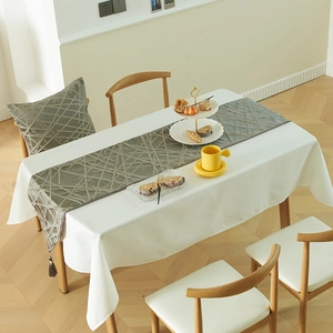 Modern sage green table runner with geometric embroidery and tassels for dining decor