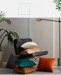 Close-up of geometric pleated velvet pillow covers in multiple colors on a chair