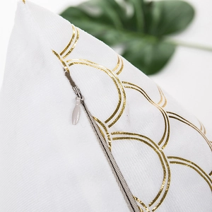 White cushion cover featuring golden geometric circle patterns and a hidden zipper closure