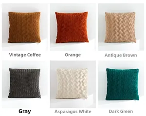 Detail of pleated velvet sofa pillows in vintage brown, orange, grey, and green