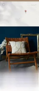 Detail of tufted leaf pattern on cream-colored cushion with fringe on leather chair