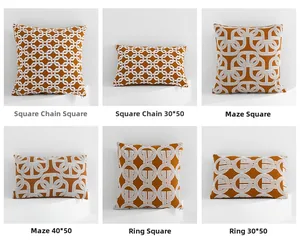Detail of geometric pillow covers in Maze and Square Chain patterns on orange fabric