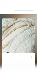 Macro shot of minimalist tufted leaf pattern on creamy white cotton linen cushion