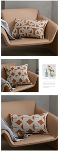 Detail of caramel orange geometric jacquard pillows on a leather sofa with textured fabric