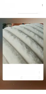 Detail view of the thick soft faux fur plush texture on a white decorative cushion