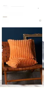Detail of orange faux fur cushion with wide stripe texture on a stylish wooden chair