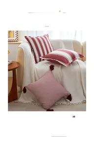 Detailed view of red and white striped cotton-poly pillow covers with decorative tassels