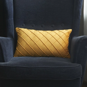 Cojín lumbar de terciopelo amarillo con textura plisada artesanal en silla azul