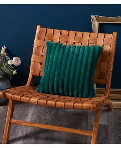 Close-up of dark green plush pillow with vertical stripe texture on a leather chair