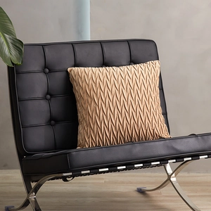 Square geometric velvet pillow in light coffee color with pleated texture on black chair