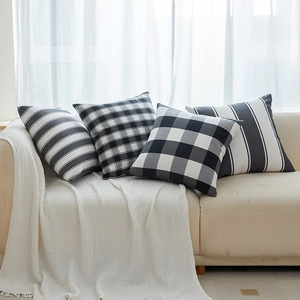 Set of four minimalist black and white geometric pattern decorative throw pillows on a sofa