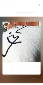 Nahaufnahme von weißem Teddy-Plüsch-Kissenbezug mit minimalistischer Gesichtslinien-Stickerei