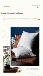 Detail of white geometric textured pillow covers with black tassels and hidden zipper