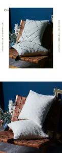 Detail of cream cotton jacquard pillow cover with black tassels and geometric patterns