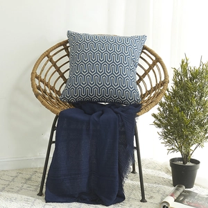 Blauer Kissenbezug mit geometrischem Jacquard-Muster auf einem Vintage-Stuhl