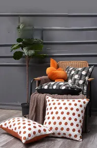 Close-up of Nordic chenille pillow covers with geometric patterns and orange knot cushion
