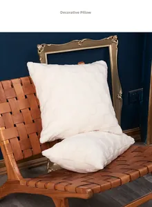 Dettaglio di cuscini bianchi in peluche con trama jacquard 3D a scacchi su sedie marroni