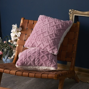 2er-Set Plüsch-Jacquard-Kissen in Lila und Weißem Sherpa-Stoff auf einem Ledersessel