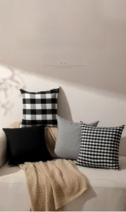 Detailed close-up of 4-piece black and white plaid and striped pillow covers on sofa