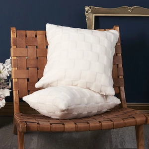 White checkered plush throw pillows on a brown leather chair for home decor