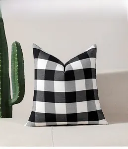Detail of black and white checkered cushion cover on sofa in minimalist Nordic style