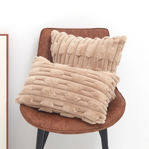 Beige faux rabbit fur cushion covers with embossed wheat pattern on brown leather chair