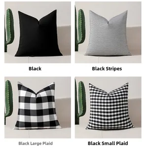 Set of four cushion covers featuring black white stripes and plaid patterns on a sofa