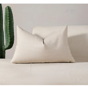 Close-up of khaki and white striped lumbar cushion on a beige textured sofa