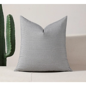 Detailed close-up of minimalist black and white striped square cushion cover on a sofa